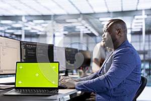 Server room programmer using green screen laptop