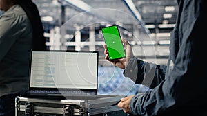 Server room software developer using mockup phone