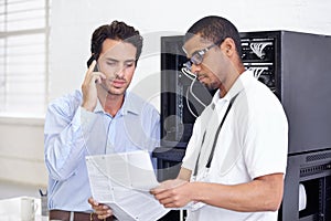 Server room, it support and phone call with a man technician reading about cyber security installation. Network