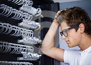 Server room, thinking and confused man with cables for connectivity, night and check hardware. Cybersecurity system, it