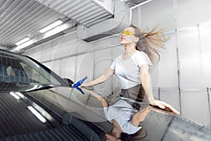 Service car wash express. Girl worker uses turbo dryer to remove drops of water