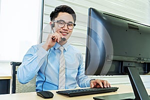 Service desk consultant talking on hands-free phone,  Portrait of happy smiling male customer support phone operator at workplace