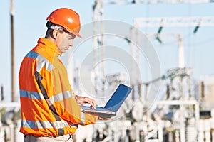 Service engineer working with laptop at heat electric power stat