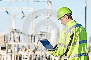 Service engineer working with laptop at heat electric power stat