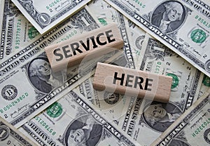 Service here symbol. Concept words Service here on wooden blocks. Beautiful dollar background. Business and Service here concept.