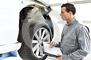 Service and inspection of a car in a workshop - mechanic inspect