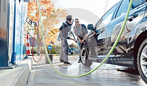 Service man helping woman cleaning her auto in car wash