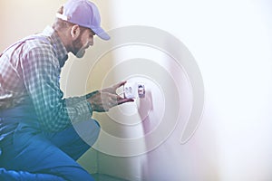 Service man installing power socket in wall