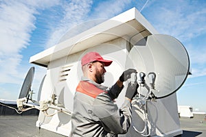 Service worker installing and fitting satellite antenna dish for cable TV