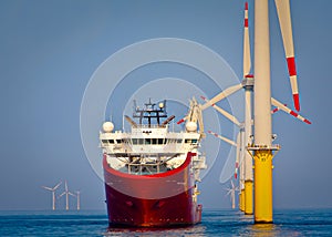 Service operational vessel standing by offshore wind turbine photo