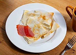 Service plate containing fried hotcakes with red caviar. Popular Russian dish photo