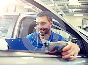 Mechanic man with diagnostic scanner at car shop