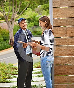Service with a smile. a male courier delivering a package to a woman at her home.