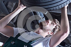 Service station worker checking tire