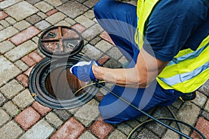 Service worker cleaning blocked sewer line with hydro jetting