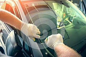 Service worker dismantle broken glass windscreen or windshield before installing new one on car in auto station garage