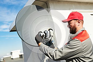 Service worker installing and fitting satellite antenna dish for cable TV