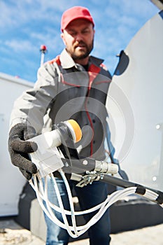 Service worker installing and fitting satellite antenna dish for cable TV