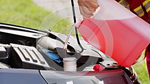 Service worker man pours car fluid windscreen red cleaning washer glass summer or winter cleaner