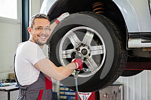 Serviceman in car workshop photo