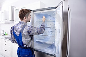 Serviceman Checking An Refrigerator