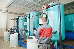 serviceman operating industrial water purification or filtration equipment