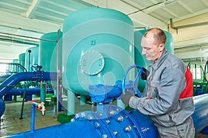 Serviceman operating industrial water purification or filtration equipment