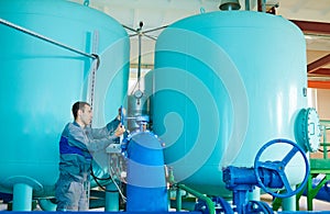 Serviceman operating industrial water purification or filtration equipment