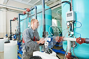 Serviceman operating industrial water purification or filtration equipment photo