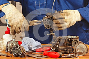 Serviceman repairing old car engine carburetor photo