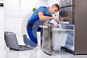 Serviceman Repairing Refrigerator photo