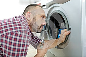 serviceman repairing seal on washing machine door