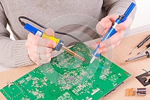 Serviceman soldering on PCB