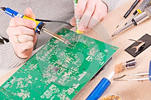 Serviceman soldering on PCB