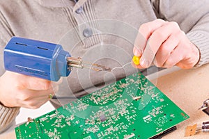 Serviceman soldering on PCB