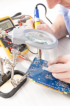 Serviceman soldering on PCB