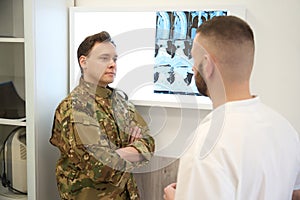 Military patient discussing results of computed tomography with doctor