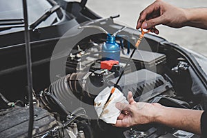 Services car engine machine concept, Automobile mechanic repairman hands checking a car engine automotive with oil level in the