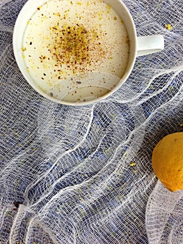 Serving of blancmange in teacup with lemon and nutmeg