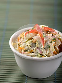 Serving of coleslaw on green background