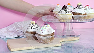 Serving Delicious cup cakes from the plate on cutting board