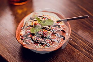 Serving of delicious frozen creamy vanilla ice cream on a modern rectangular plate outdoors on a blue rustic picnic