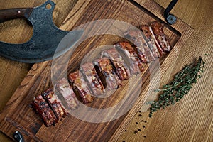 Serving of delicious roasted barbecue pork ribs on a wooden board. Beer snack. Top view food