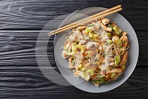 Serving filipino rice noodle bihon with vegetables and meat close-up in a plate. Horizontal top view