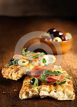 Serving of focaccia bread with ham and rocket