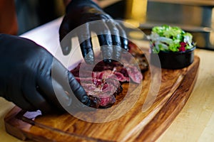 Serving freshly cooked beef steak on a wooden board