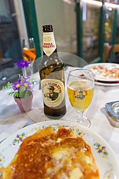 Serving a glass of Italian beer and a lasagna