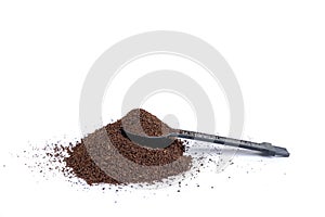 Serving measuring scoop full of coffee grounds in a hill of coffee