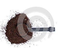 Serving measuring scoop full of coffee grounds in a hill of coffee top down view