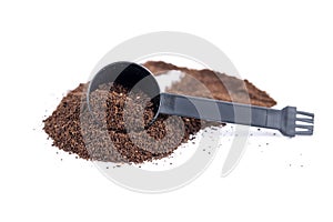 Serving measuring scoop full of coffee grounds scooped through a hill of coffee